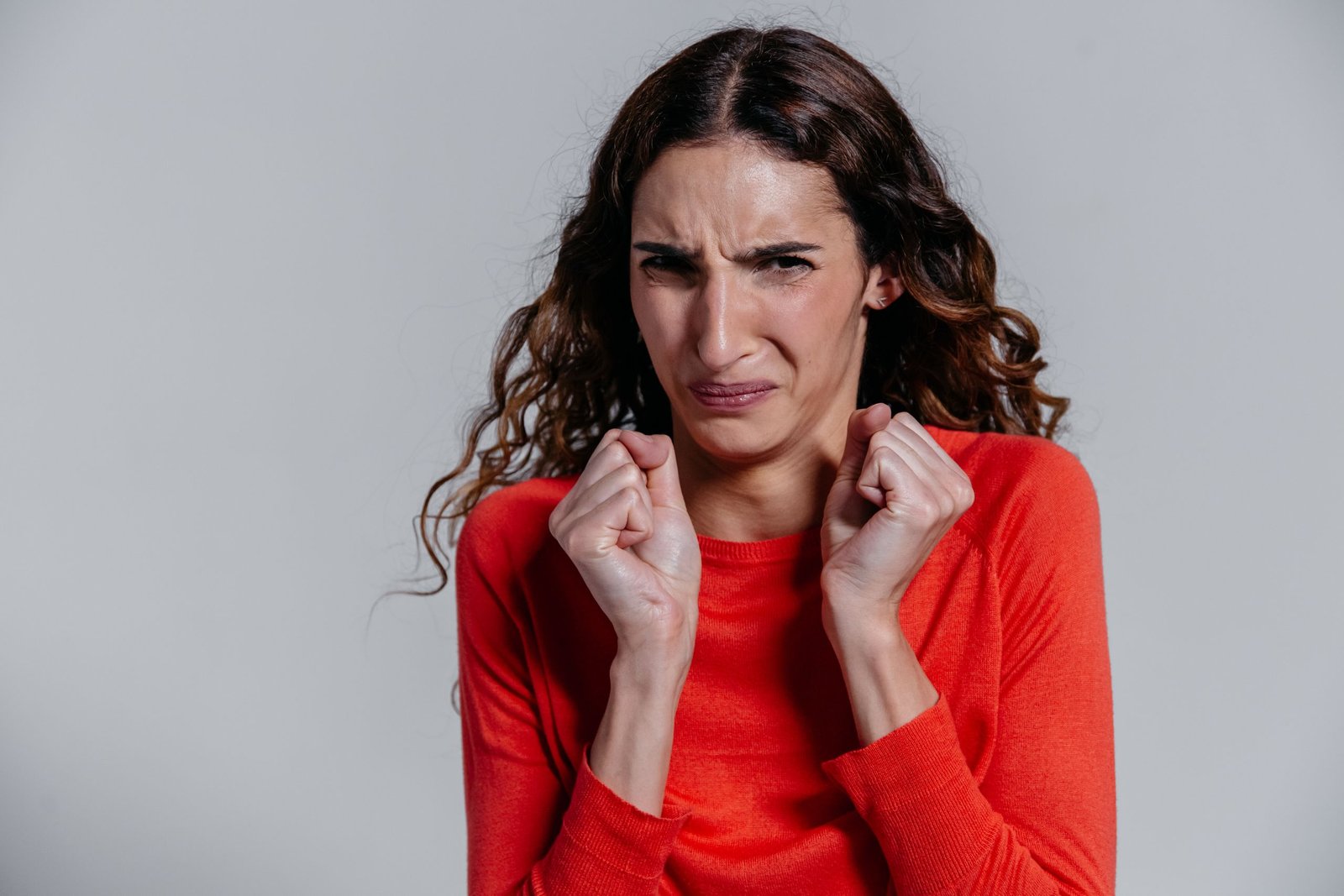 A woman displaying a disgusted facial expression indoors.